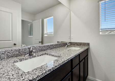 Guest bathroom with granite countertops and a dual sink vanity. 