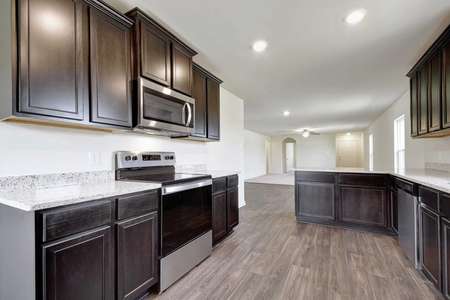 Medina kitchen finished with stainless steel appliances, custom brown cabinets, and ceramic tile flooring
