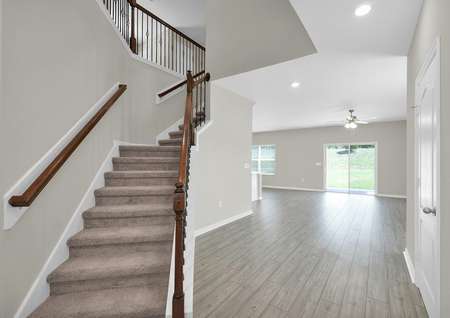 Entrance view of spacious home with stairs leading to the second floor of a two-story home.
