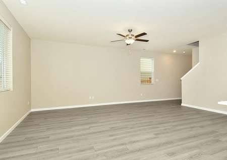 Spacious family room with ceiling fan and plank flooring