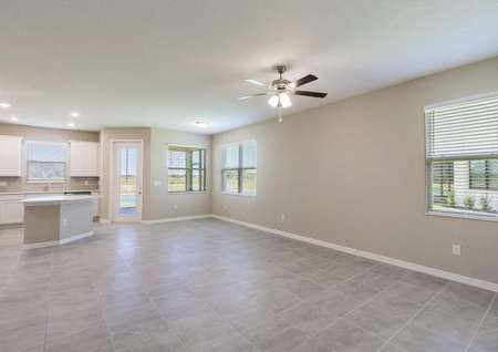 The spacious living and dining area in the Tuscany floor plan has tile floors, multiple windows and a ceiling fan with lights.