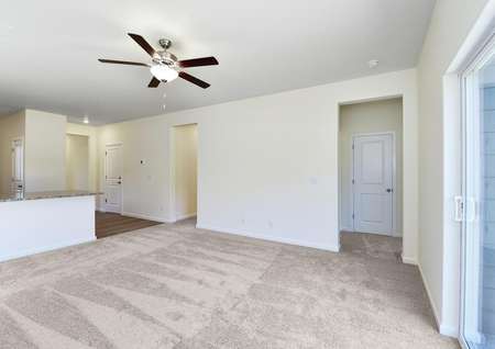 Spacious family room with carpet and a ceiling fan 
