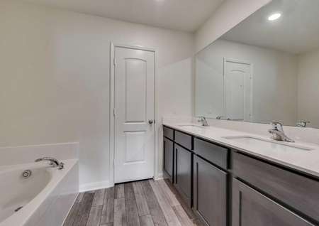 Topeka plan's master bathroom with granite countertops and double sink vanities