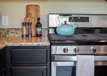 Kitchen staged with turquoise teapot, salt and pepper shaker, and cookie jar on countertop