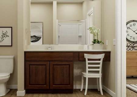 Rendering of the master bath in the
  Allatoona showcasing a large vanity with brown cabinetry and a white toilet.
  The dresser of the bedroom is visible through the open door.