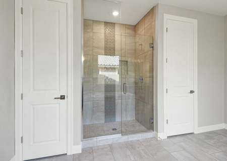 Hawley master bath with built-in shower with glass panels, storage closets, and ceramic floor