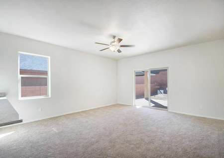 Bisbee living room with sliding patio door, carpet flooring, and brown ceiling fan