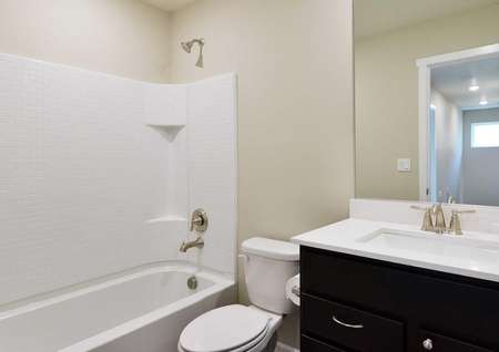 The Northwest Chelan second bathroom is shown with bathtub and shower combo with white quartz countertop.