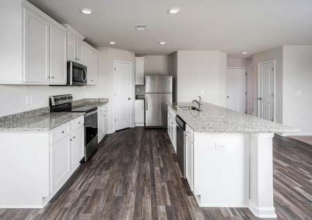 Kitchen with granite, white cabinets and stainless appliances.