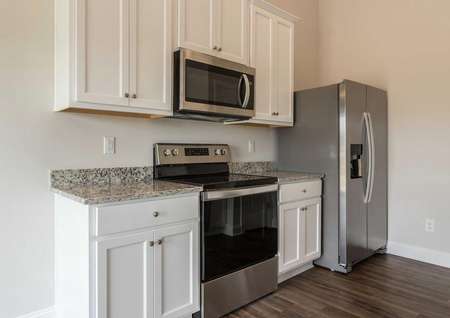 Alexander kitchen with white cabinets, granite counters, and modern appliances