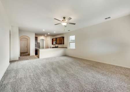 This home has an open family room with brown carpet and light walls.