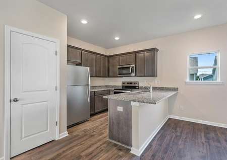 The kitchen has sprawling granite countertops, brown cabinetry and a full suite of stainless steel appliances.