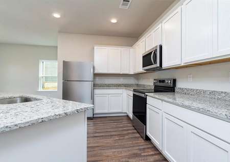 Upgraded kitchen showcasing white cabinets with crown molding and granite countertops.