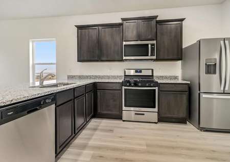Stunning kitchen with stainless appliances, granite countertops and wood-style flooring.