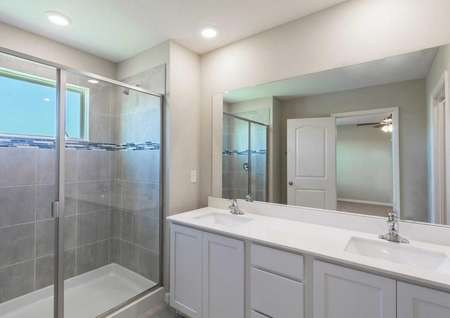 The Tuscany floor plans bathroom has a walk-in shower, white cabinetry and quartz countertops.