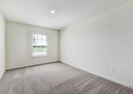 Medina bedroom with can light, white on white walls, and brown carpeting