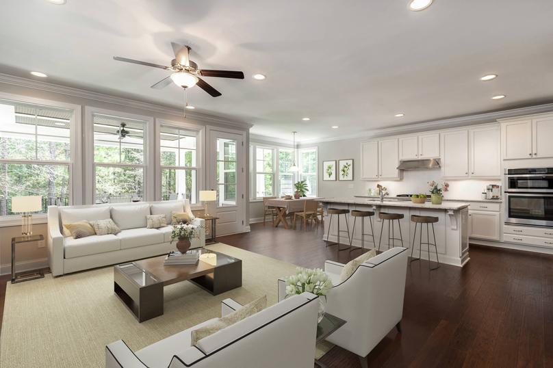 Living room and kitchen with wood floors and stainless steel appliances.