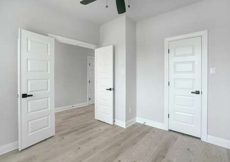 Study located off the entry with a ceiling fan, double doors, and wood flooring.