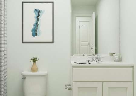 Rendering of a full bath showing a white
  cabinet vanity, toilet and shower hidden behind a striped curtain. The space
  is decorated with a candle, potted plant and abstract art.