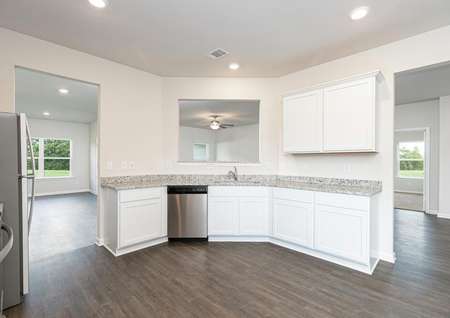 The kitchen has plenty of storage space in its beautiful white cabinets