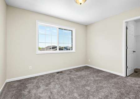 Upstairs bedroom with carpet and a window.