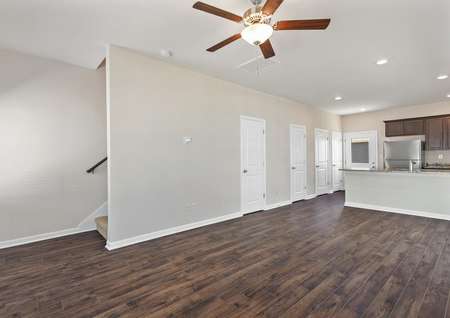 This home has an open layout with dark wood-like flooring and tan walls with white trim.