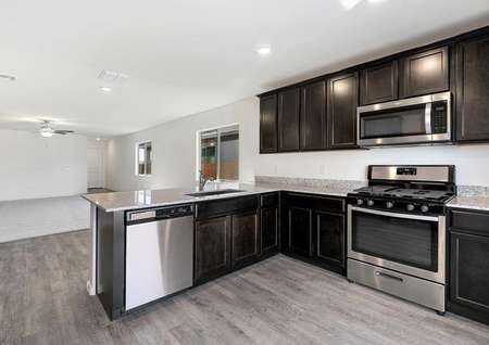 Chef-ready kitchen with espresso cabinets, granite countertops, and stainless appliances.