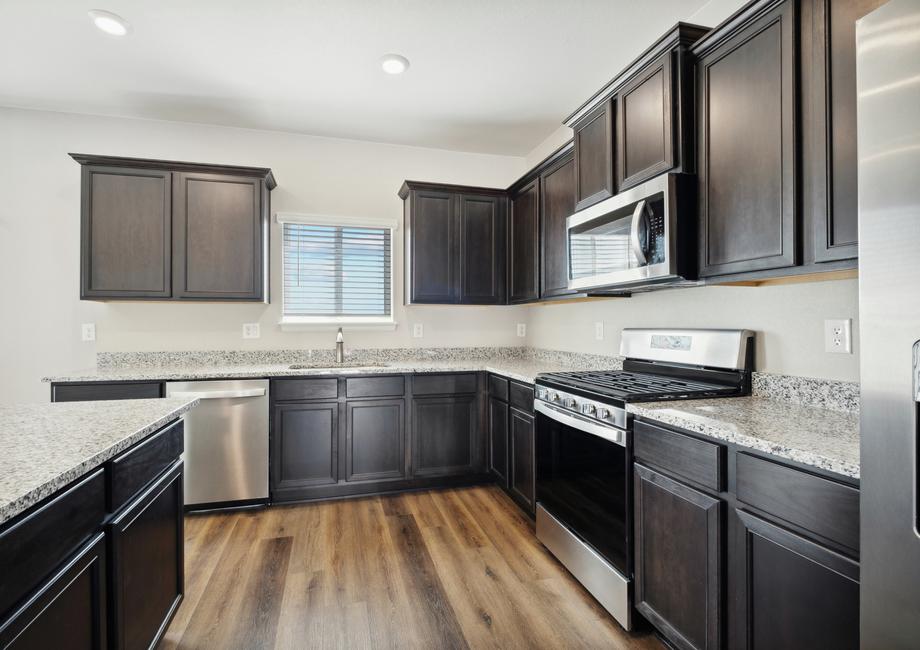 Stunning kitchen features include espresso cabinetry and wood-style flooring.