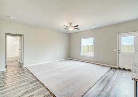 The layout's family room is carpeted and allows for plenty of natural light to enter.