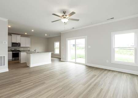 Open family room, kitchen and dining room with windows and a sliding glass door to the back yard.