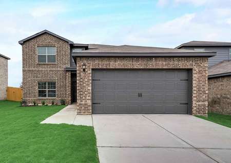 Oakmont brick exterior view with 2 car garage, shingle roof, and green grass landscaping