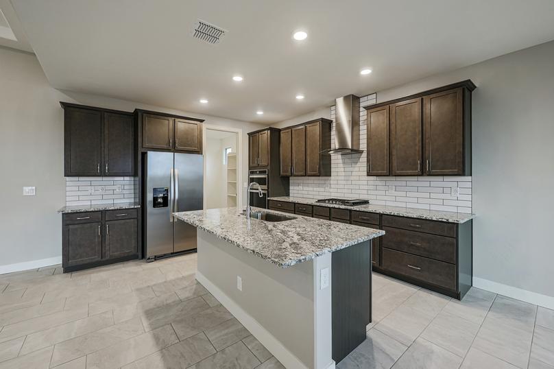 The modern chef-ready kitchen featuring granite countertops, luxe wood cabinetry, and designer finishes.