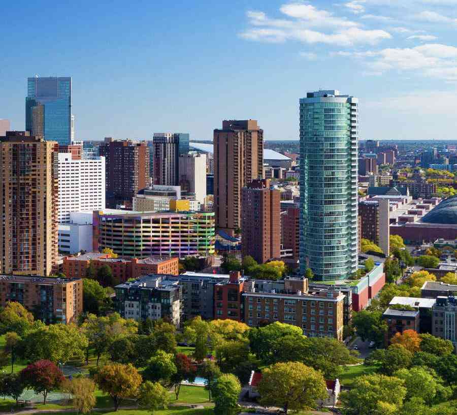 Minneapolis, Minnesota downtown cityscape showing park with ponds, green grass and paths, and plenty of trees