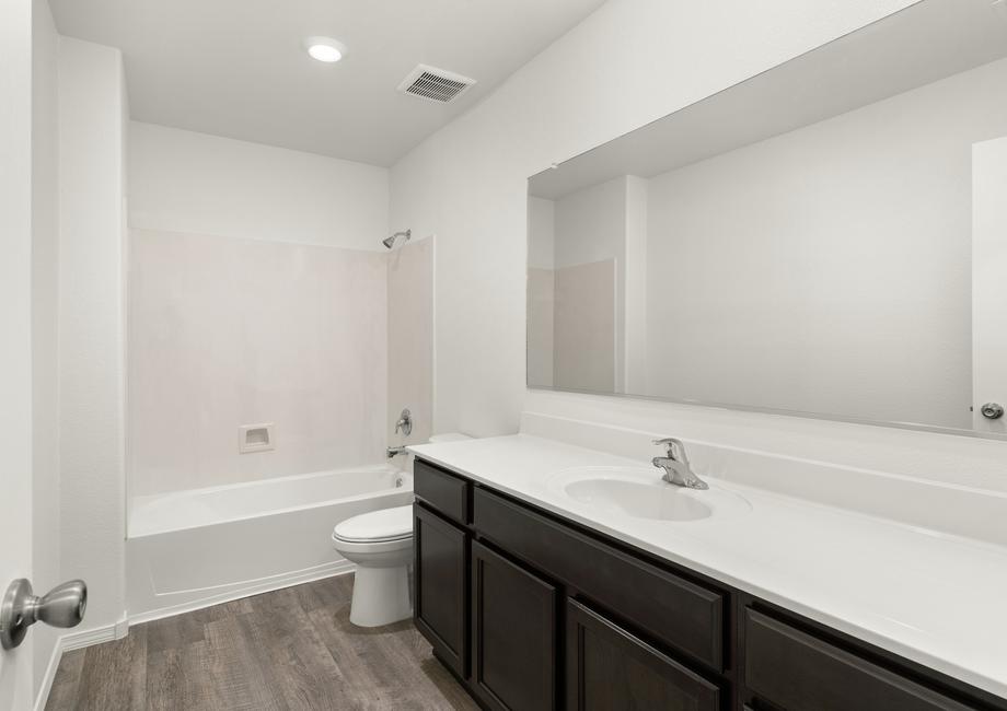 Secondary bathroom with wood-style flooring and a dual shower and tub.