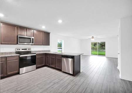 Kitchen angle with a view of stainless steel appliances and a large family room.
