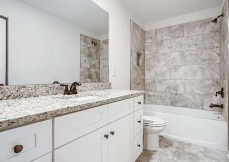 Secondary bathroom with stunning tile and a dual shower and tub. 