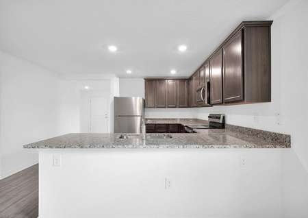 The kitchen's granite countertops, upper-wood cabinets and stainless steel appliances. 