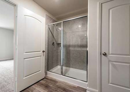 Sabine master bath with custom tile shower stall, wood floors, and off white walls
