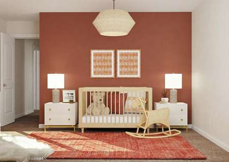 Rendering of a secondary bedroom
  decorated as a nursery with a crib, two nightstands, a rocking horse and
  dresser. The space has a rust-colored accent wall and carpeted flooring. 