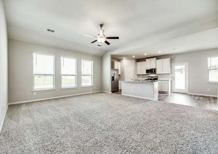 The family room is highlighted by large windows and is open to the kitchen.