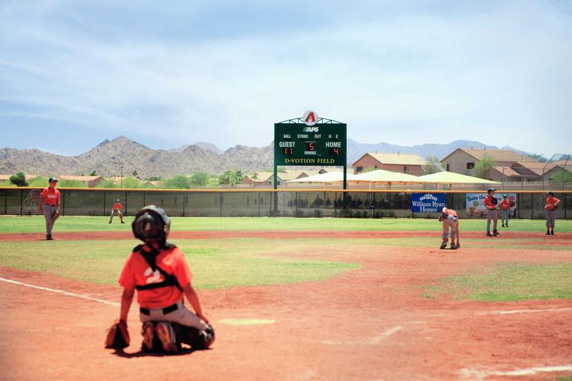 Outdoor baseball field with children playing on the field in the Estrella community