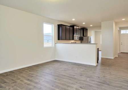 Columbia great room with wood flooring, white trimmed walls, and kitchen counter