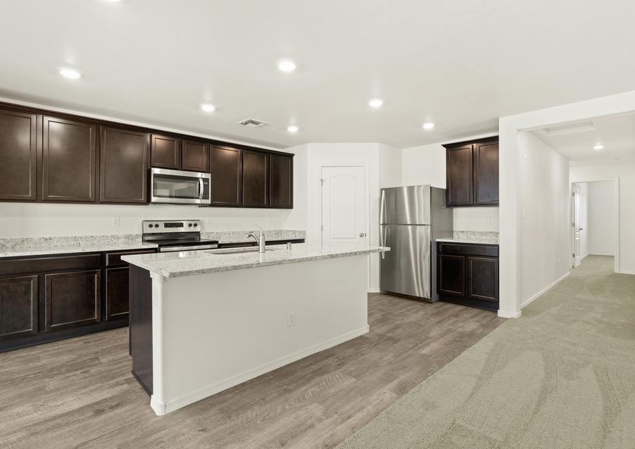 Chef-ready kitchen with a large granite island and recessed lighting.