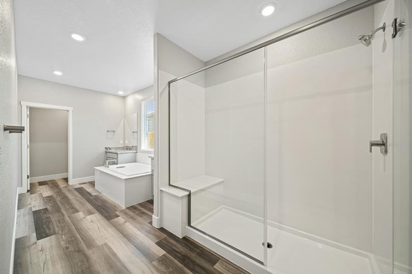 Master bathroom with two vanity areas, a soaking tub, and a walk-in shower.