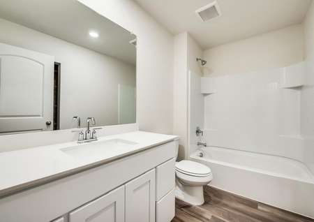 A full bathroom with plenty of storage space and modern hardware. 