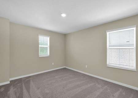 Sizable bedroom with multiple windows, allowing for plenty of natural light to enter. 