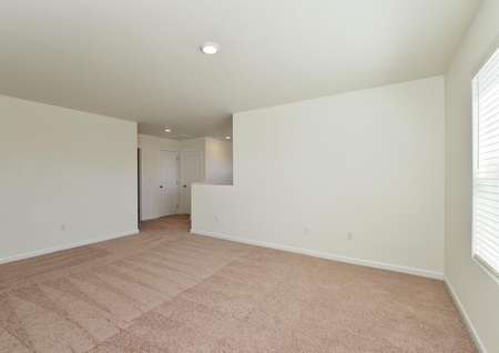 Spacious upstairs game room has carpet, window and recessed light.