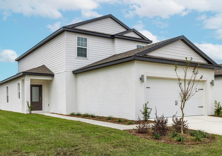 The Dade by LGI Homes welcomes you in with beautiful front yard landscaping and a 3/4 lite door