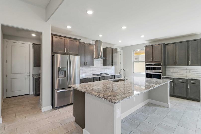 Hawley kitchen with stainless steel appliances, large granite island with eating bar, and brown wood cabinets