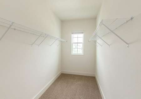 Large walk-in closet with plenty of storage space and a window overlooking the front of the home.